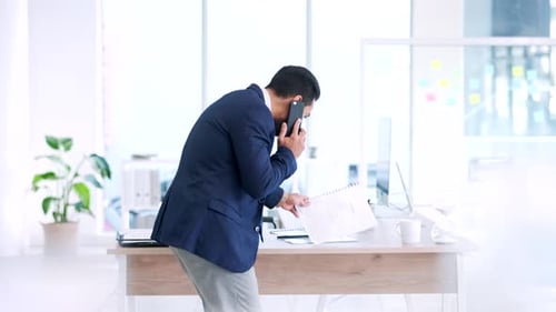 Young Adult Businessman Talking on Cellphone in Office
