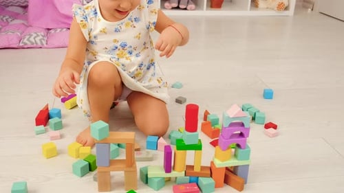 Girl Building Colorful Tower with Wooden Blocks