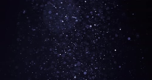 Weiße Bokeh-Partikel, die in der Dunkelheit herumwirbeln
