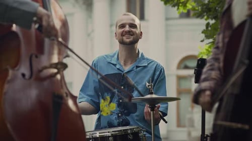 Drummer Plays with Musicians in Public Park