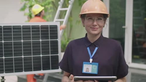 Portrait of Female Engineer with Tablet beside Solar Panel Outdoors