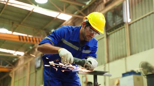 Kaukasischer gutaussehender männlicher Industriearbeiter arbeitet in einer Produktionsstätte.