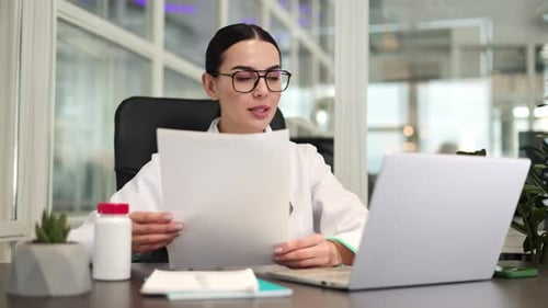 Doctor Reviews Medical Data Online at Desk