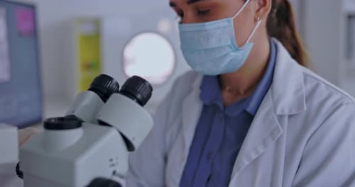 Woman Researcher Works in Medical Lab with Microscope