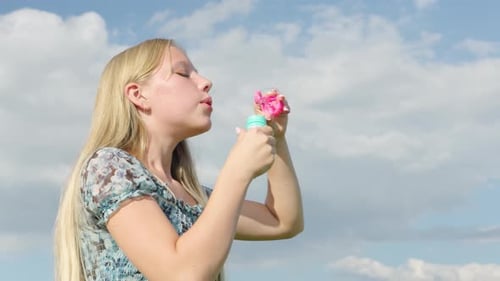 Joyful child making colorful bubbles on a sunny day in the park