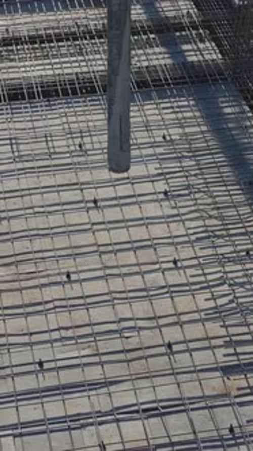 Vertical Video of Workers Building Walls While a Crane Lifts Heavy Materials and Engineers Supervise