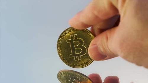 Hand Holding a Golden Bitcoin Cryptocurrency Coin
