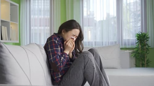 Sick woman sneezing, runny nose and not feeling well.