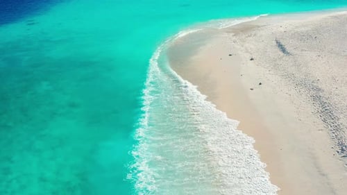 Luftaufnahme von weißem Sandstrand und türkisfarbenem Meer mit Wellen auf der tropischen Insel Ukulhas, Malediven
