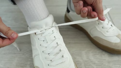 Close Up of Hands Tying Shoelaces on Shoes