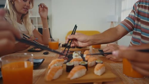 Group of friends eating sushi together at home.