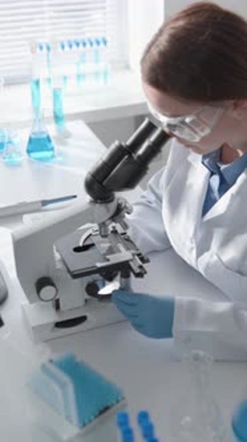 Scientist Uses Microscope for Research in Lab