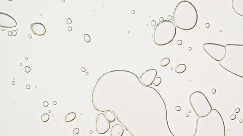 Abstract Oil Drops Forming Shapes on Neutral Background