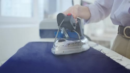 Woman's Hand Irons Fabric Tailor Designer Seamstress Woman Ironing Pattern Close Up