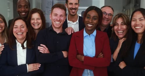 Multi generational workers smiling in front of camera inside business office