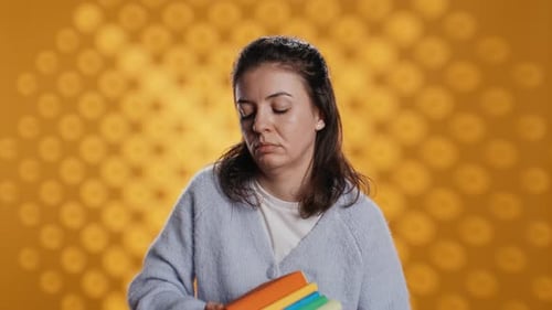 Exhausted Woman Yawning Holding Heavy Stack of Books Needed for School Exam