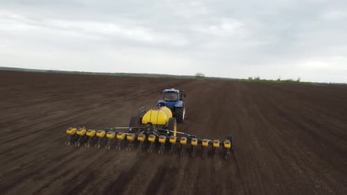 Blauer Traktor OA arbeitet auf dem Feld in der Ukraine