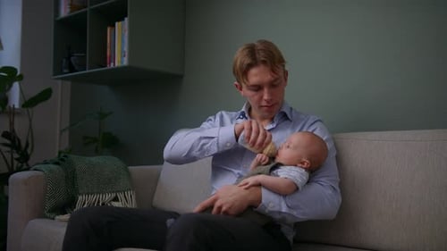 Father Feeding Baby Boy From Bottle