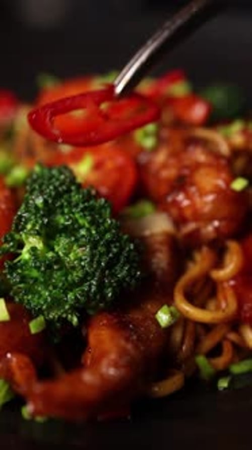 Asian Noodle Stir Fry Dish Being Garnished