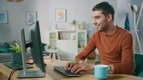Un
guapo ingeniero de software trabaja en una Plantilla de Aplicación Móvil de UX/UI, utiliza una computadora personal. Freelance