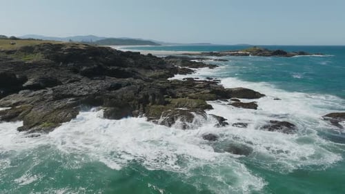 Drone clip of waves crashing onto rocky shoreline in Australia