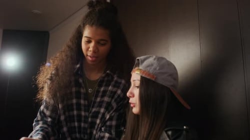 Adolescentes multiethniques discutant de partitions pendant la répétition du groupe