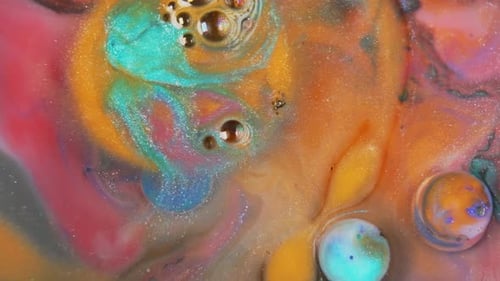 Colorful ink swirling in water, abstract mix of orange, yellow, and blue tones, close-up