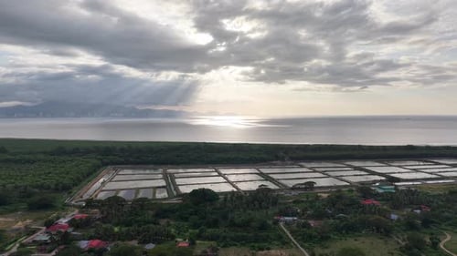Aerial drone view of coastal saltpans under sun rays