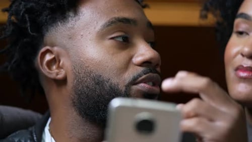 Pareja sincera que usa el teléfono en una conversación viendo comentarios de entretenimiento