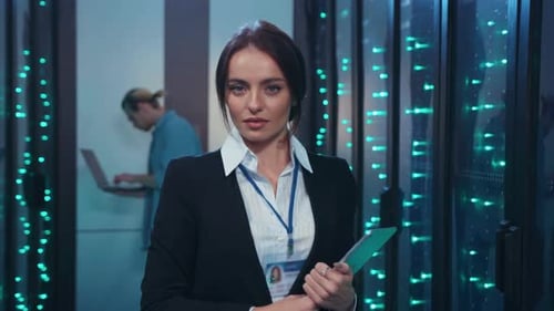 Woman in Data Center Holds Tablet Computer