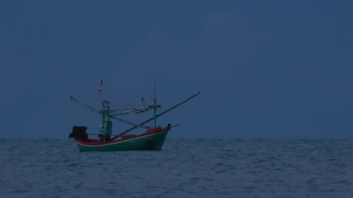 Fishing Boats in Thailand wait in the middle of the ocean for dark to come so they can turn on their
