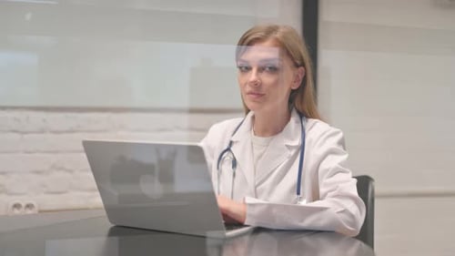 Smiling Young Doctor Looking at Camera in Hospital
