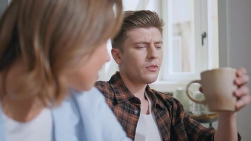 Couple Conversing Indoors at Table Over Drinks