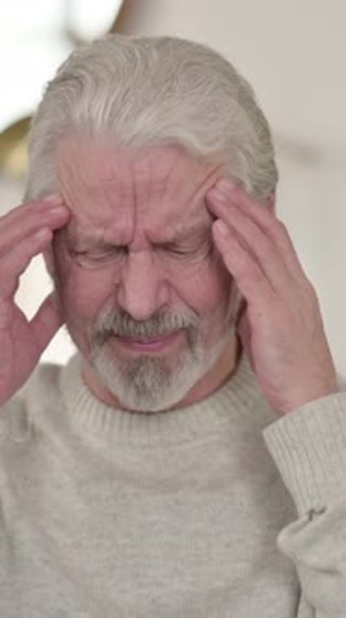 Senior Man Rubbing Temples in Pain