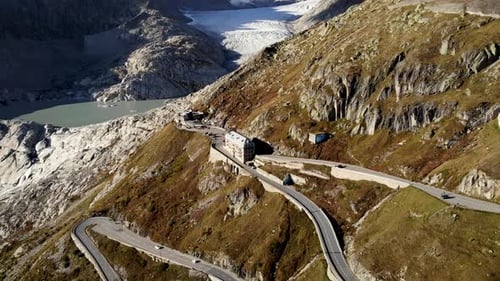 Aerial flyover over Furka mountain pass at the border of Valais and Uri in Switzerland with a pan do