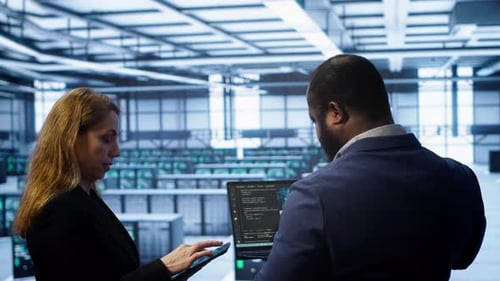 Data Center Coworkers Doing Yearly Maintenance Using Laptop and Tablet