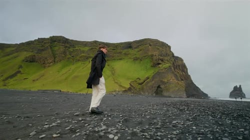 A Young Man Stands at Reynisfjara Black Sand Beach on the South Coast of Iceland