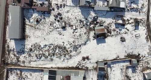 Eine verschneite Landschaft mit ein paar Gebäuden im Hintergrund