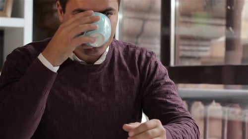 Man Enjoys the Aroma of the Coffee at the Cafe