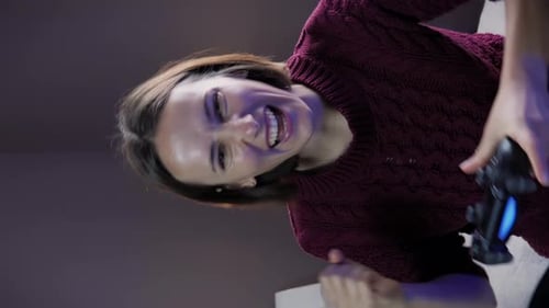 Frau spielt Online-Videospiele mit drahtlosem Joystick. Vertikales Video