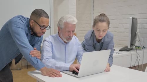 Team Working Together on a Laptop in Office