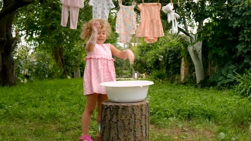 The Child is Washing Clothes in the Garden Selective Focus