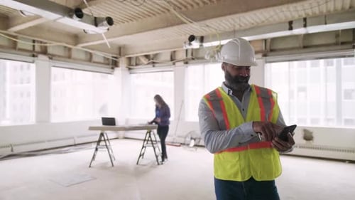 Of Construction Foreman on Phone in Empty Building