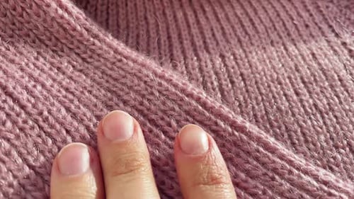 Close Up Hand Stroking Over the Surface Knitted Soft Wool Cloth or Warm Fluffy Sweater Handcraft