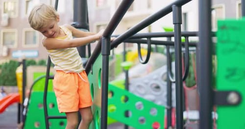Child Climbing on Playground Equipment Outdoors