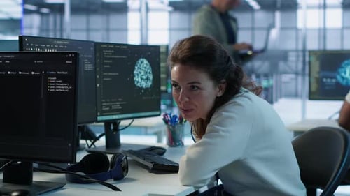 Woman Coding and Conversing in Modern Office