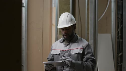 Male Builder Using Tablet while Working on Construction Site