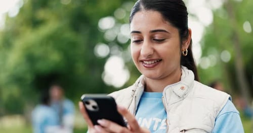 Smiling Woman Using Phone Outdoors with Blurred People