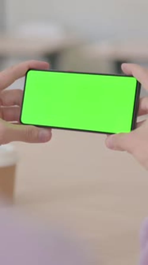 Rear View of Man Holding Smartphone with Green Chroma Screen, Vertical Video
