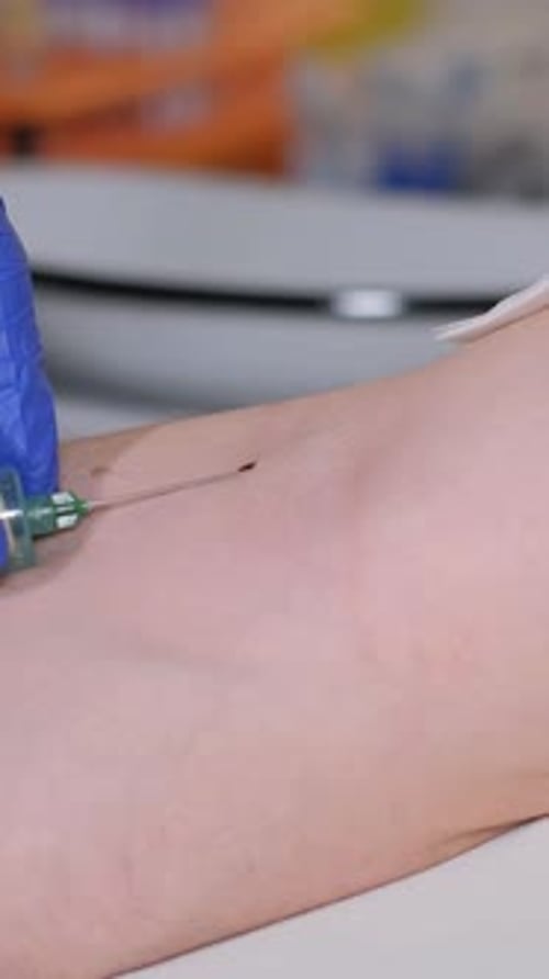 Healthcare Professional Inserting Needle Into Patient's Arm